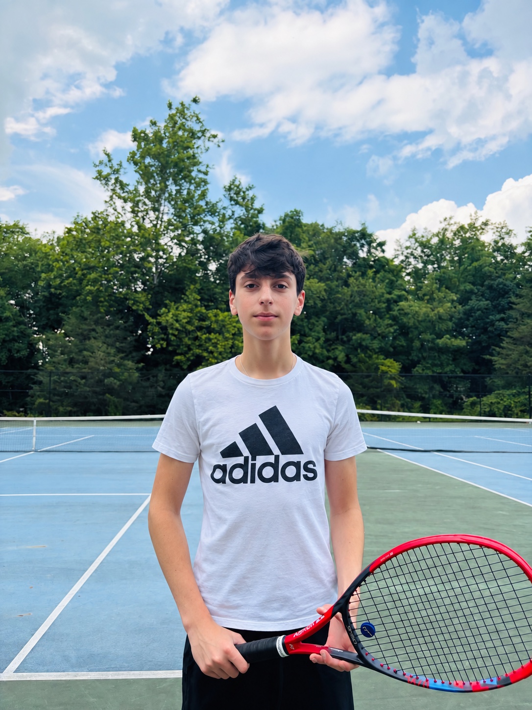 Elliot Lavian holding a tennis racket on a court