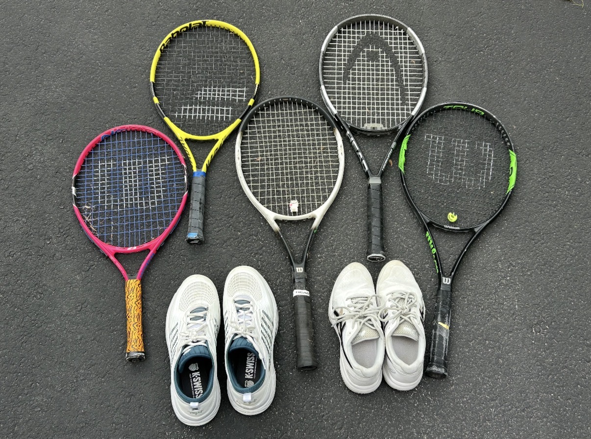 Five tennis rackets and two pairs of shoes arranged together